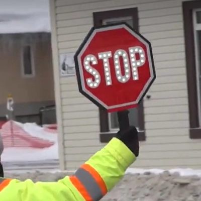 in use image of crossing guard using paddle sign